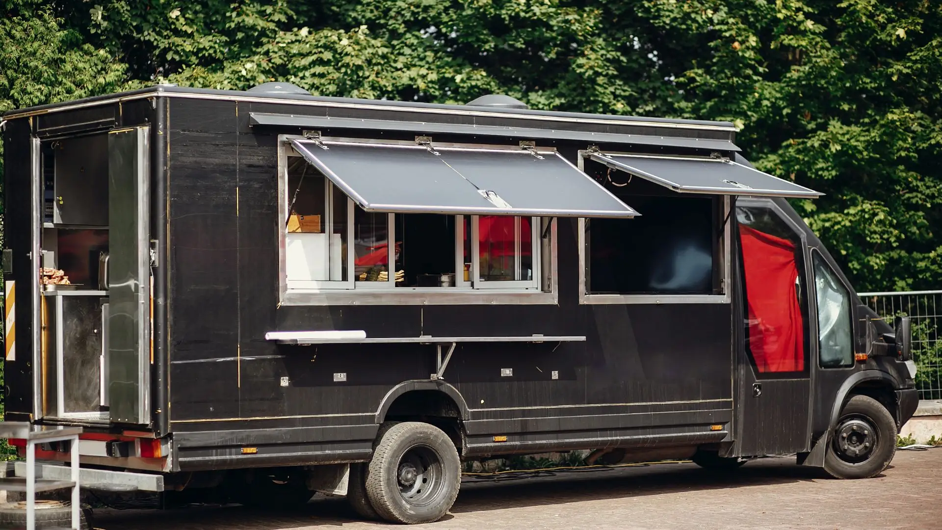 A black food truck parked outside.