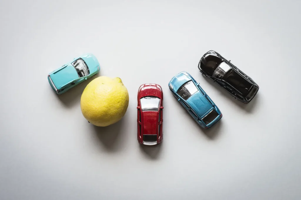 Four toy cars with a lemon on the left side.