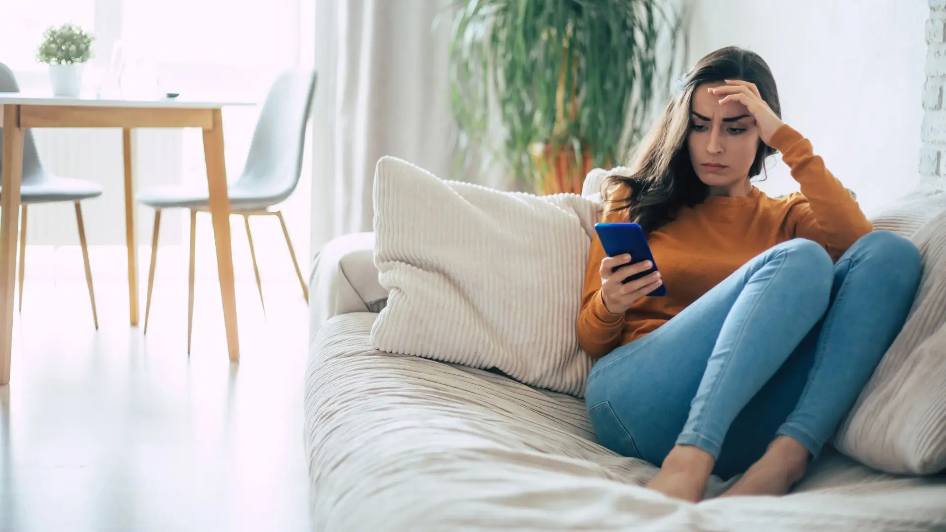 A woman looking at her phone in confusion.